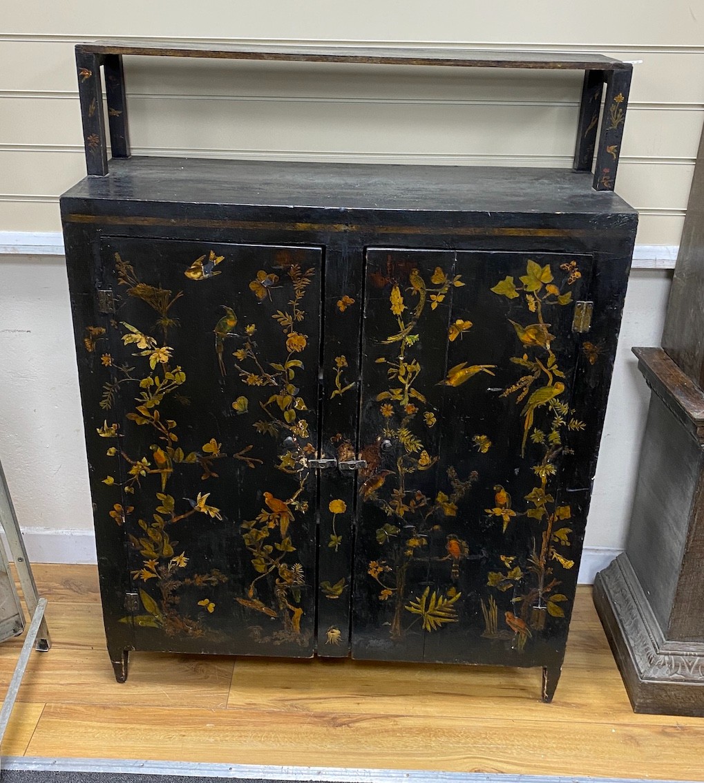 A late 19th century black painted decalomania decorated two door cupboard, width 92cm, depth 36cm, height 123cm